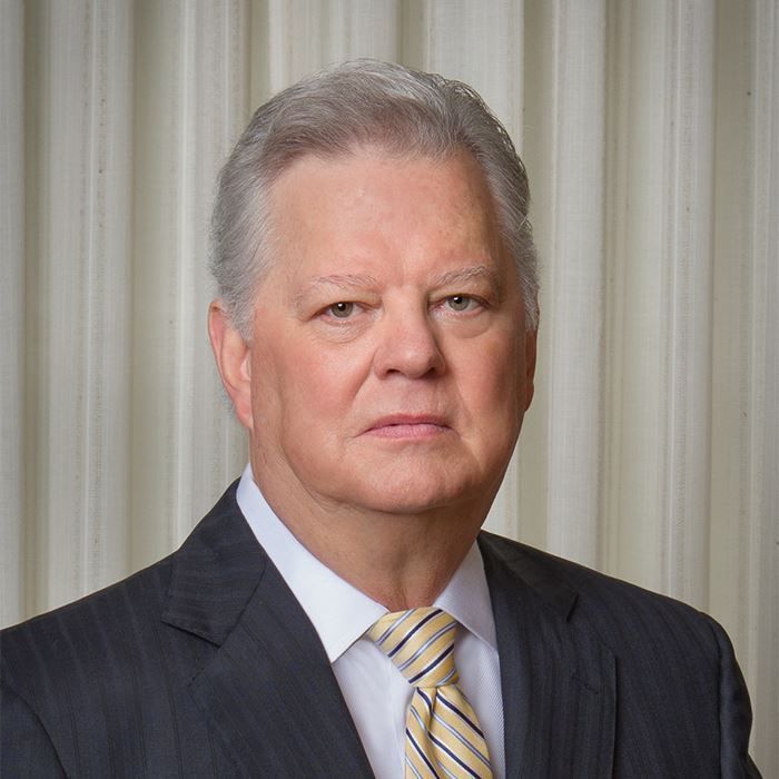 Formal portrait of a middle-aged man in a suit and tie, looking directly at the camera.