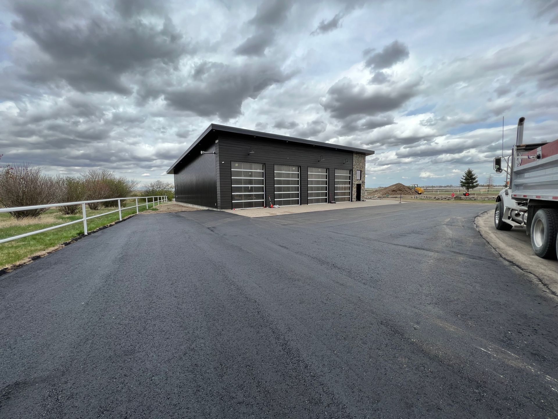 A truck is parked in front of a garage on a cloudy day.