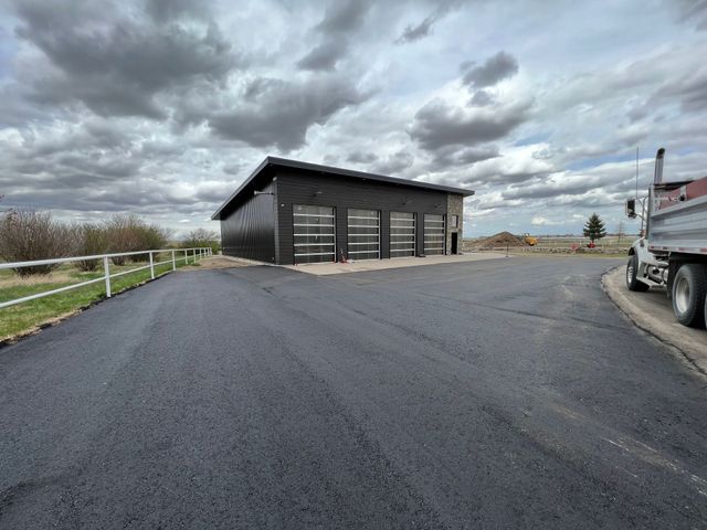 A truck is parked in front of a garage on a cloudy day.