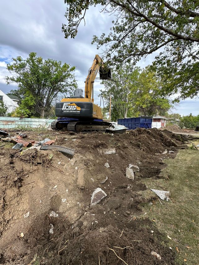 A large excavator is working on a pile of dirt in a field.