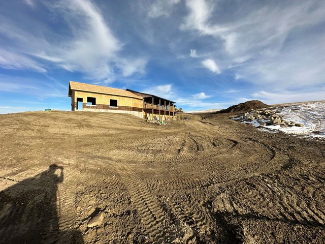 A house is being built on top of a dirt hill.