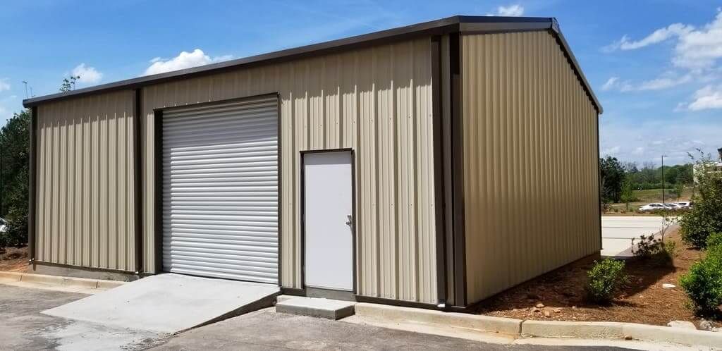 A large metal building with a garage door and a doorway.