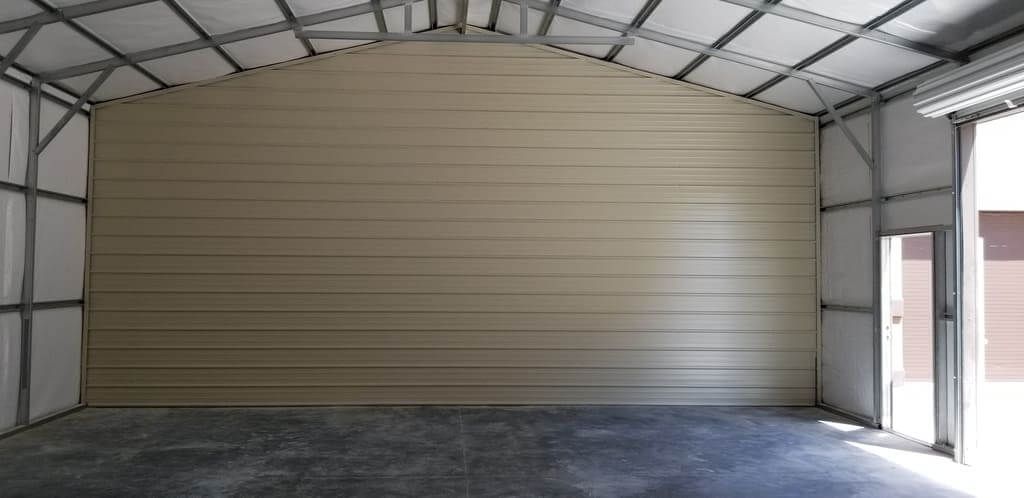 An empty garage with a large wall and a door.
