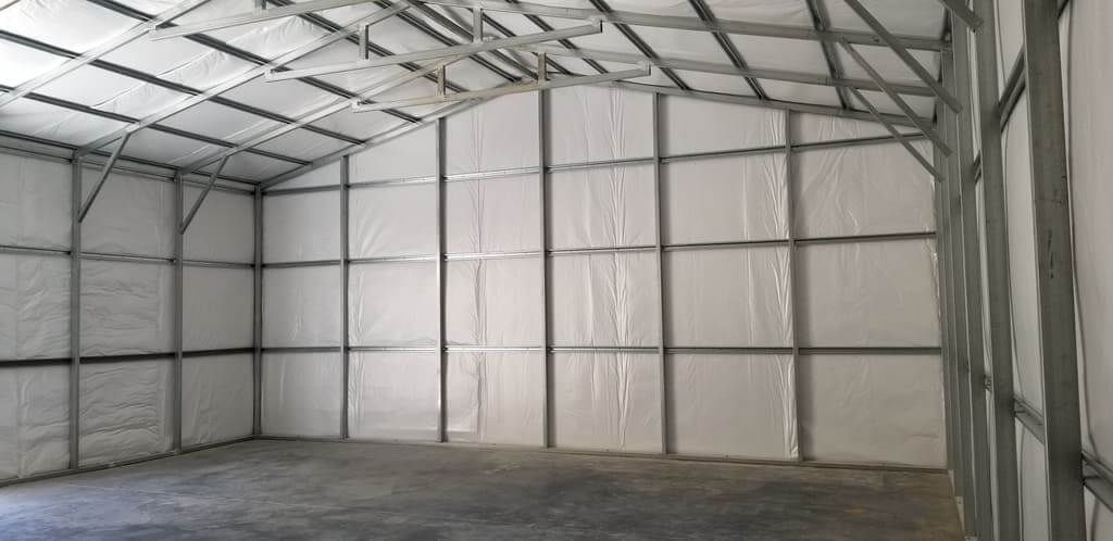 A large empty warehouse with white walls and a concrete floor.