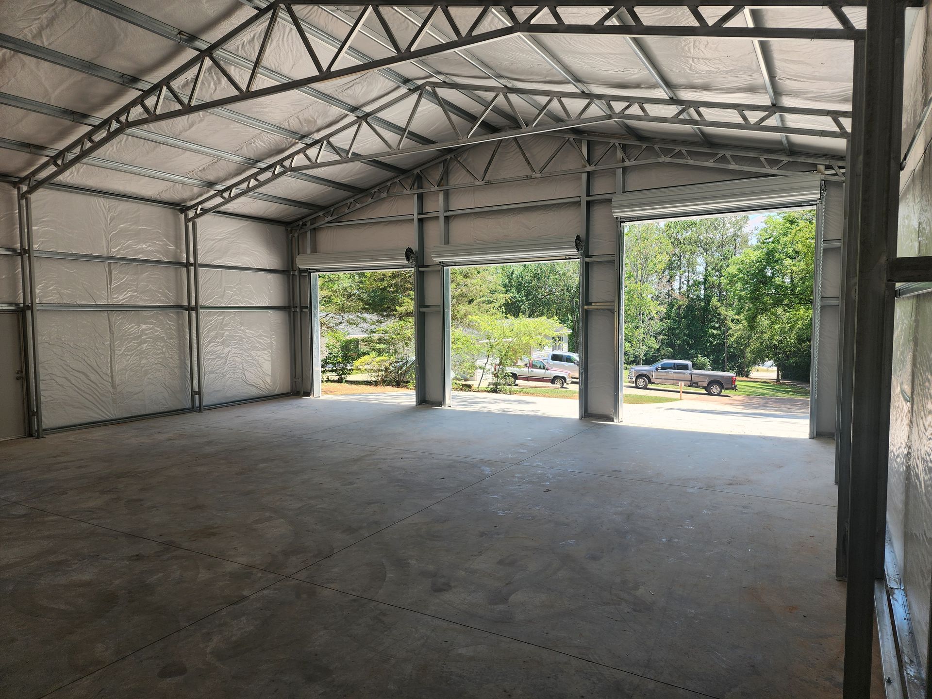 A large empty warehouse with a lot of doors open.