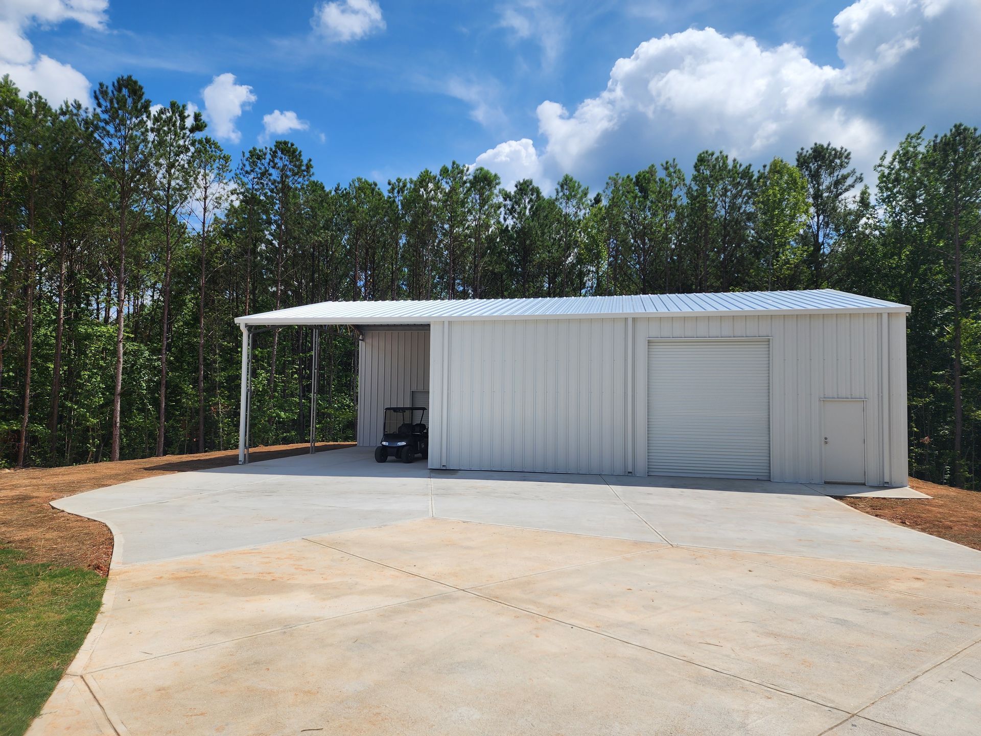 A white garage with a car parked underneath it
