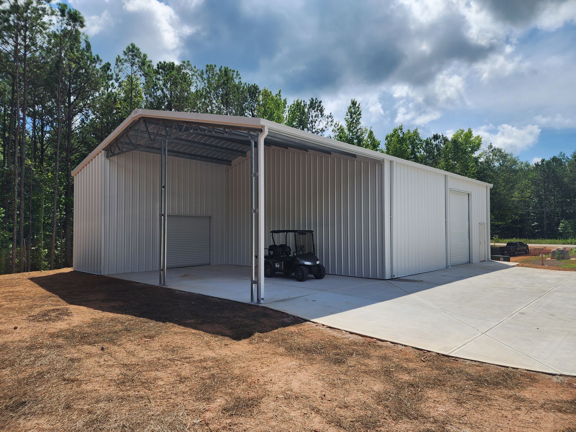 A golf cart is parked inside of a metal building.