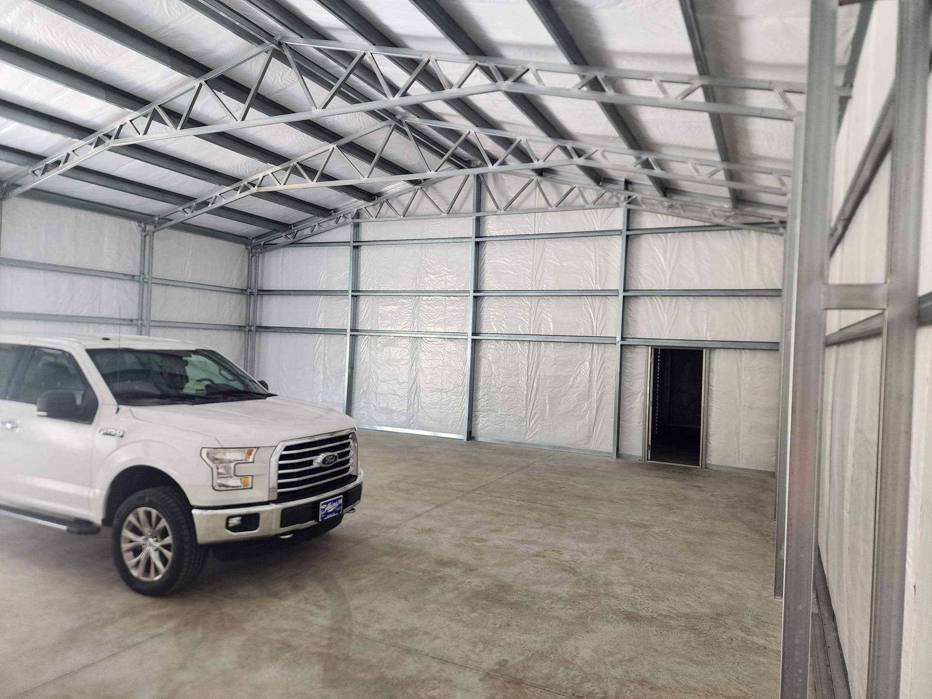A white truck is parked in a large warehouse.