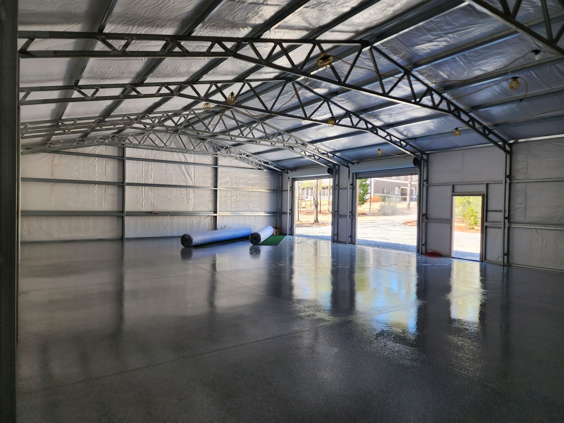 A large empty warehouse with a concrete floor and a metal roof.