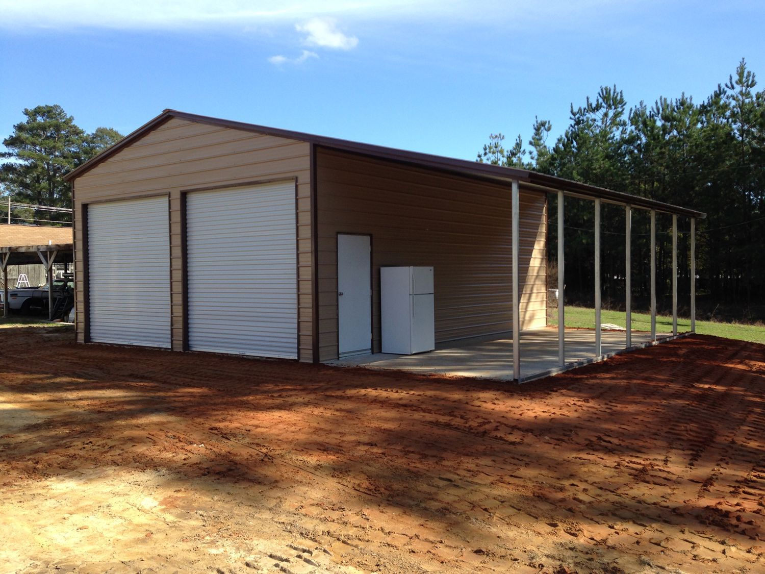 A garage with a porch and a refrigerator inside of it