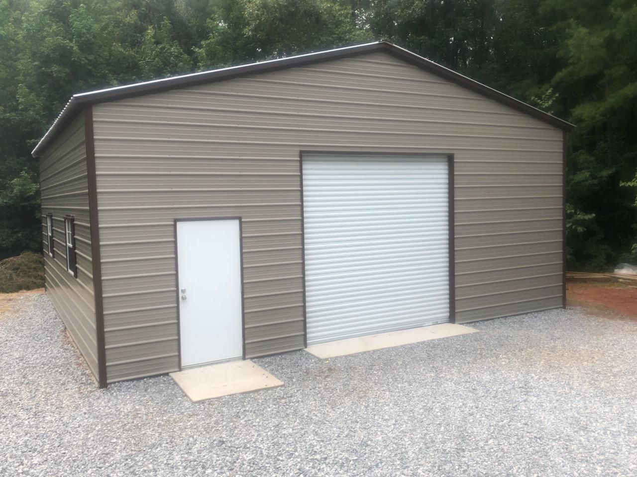 A metal garage with a white door and a roll up garage door.