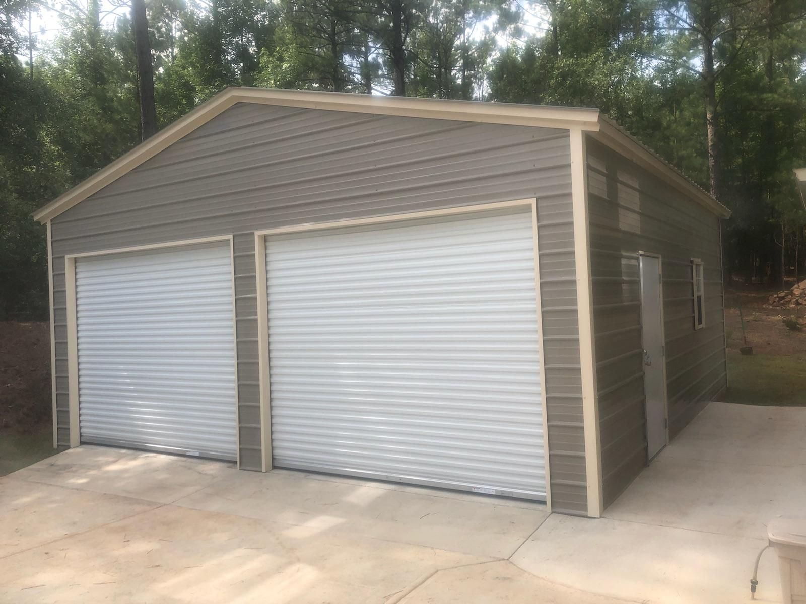 A garage with two garage doors and a concrete driveway.