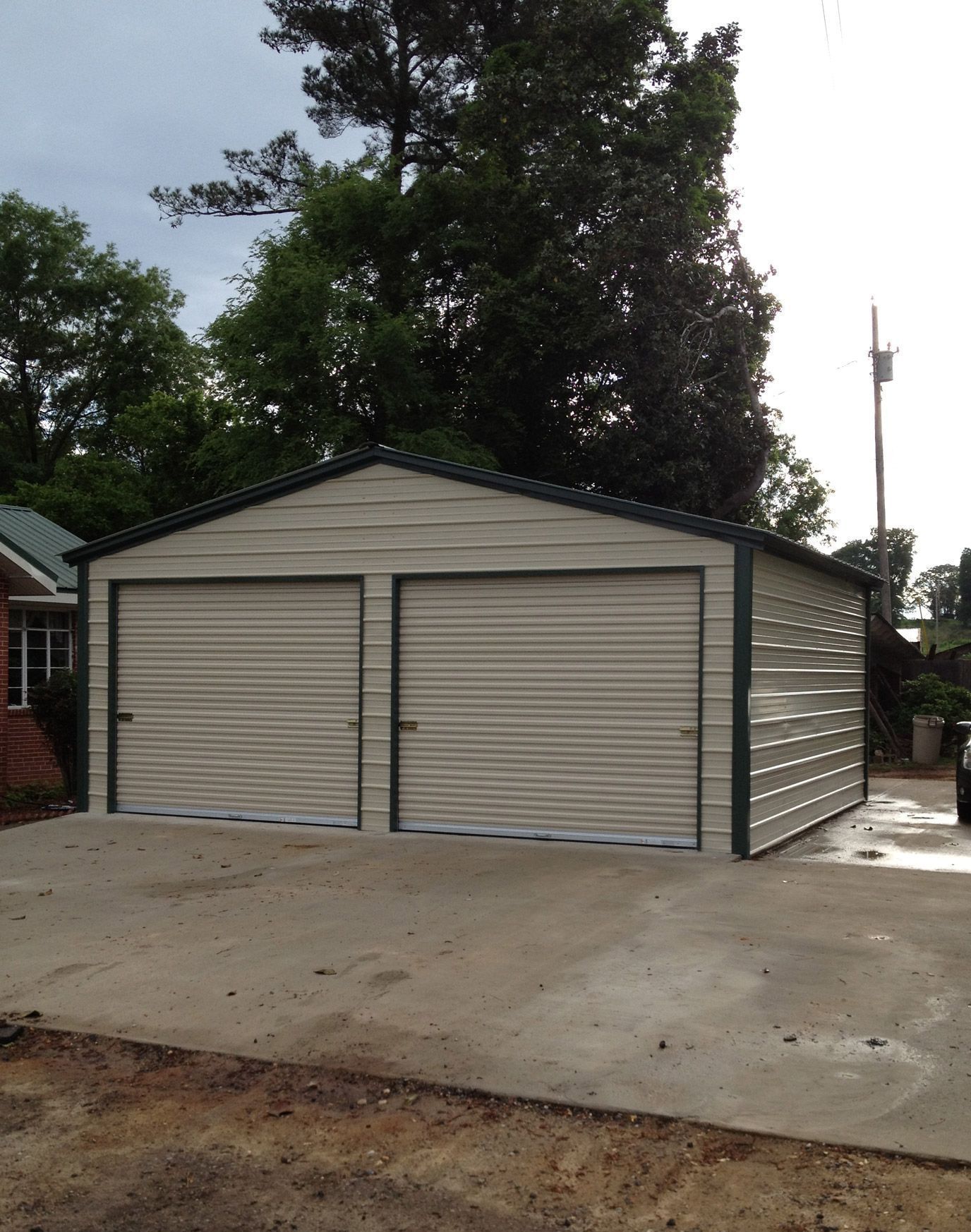 A white car is parked in front of a garage