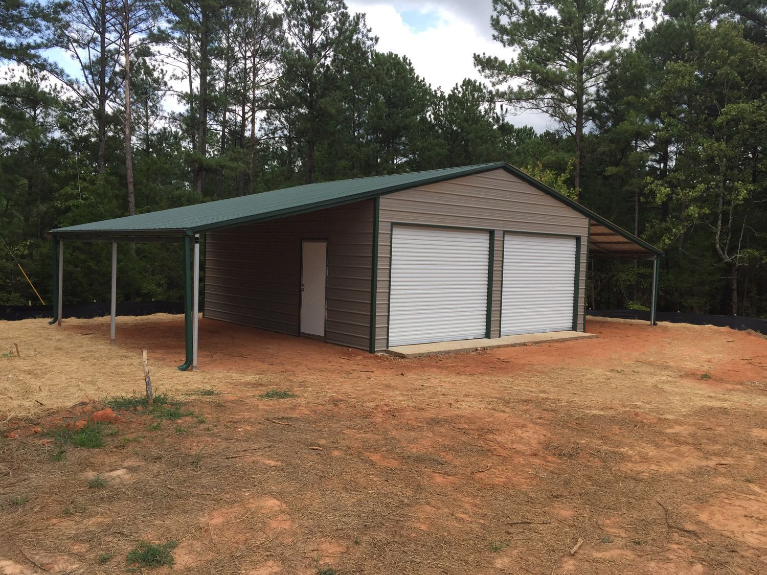 A garage with a green roof and white doors