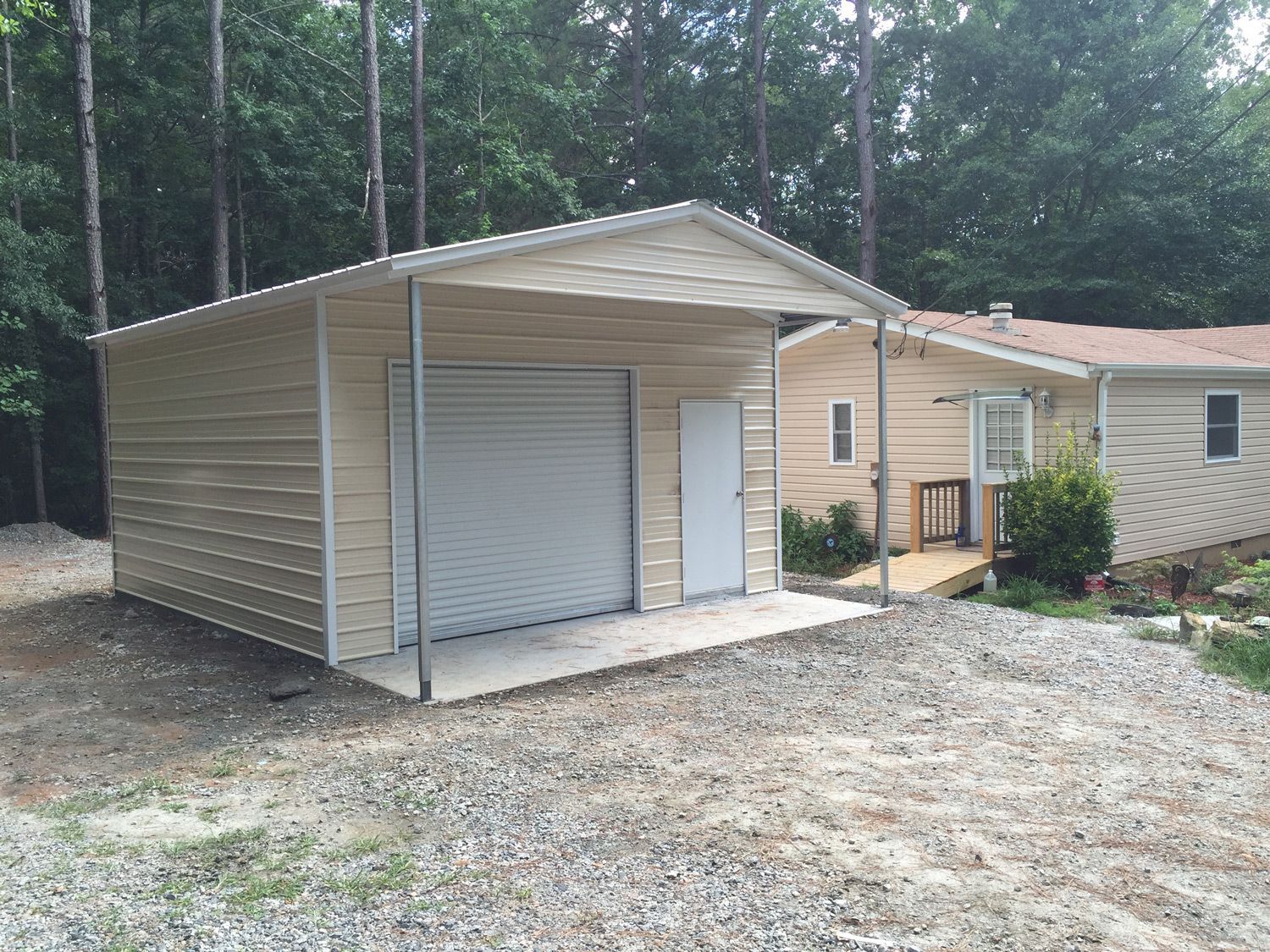A garage with a porch is next to a house.