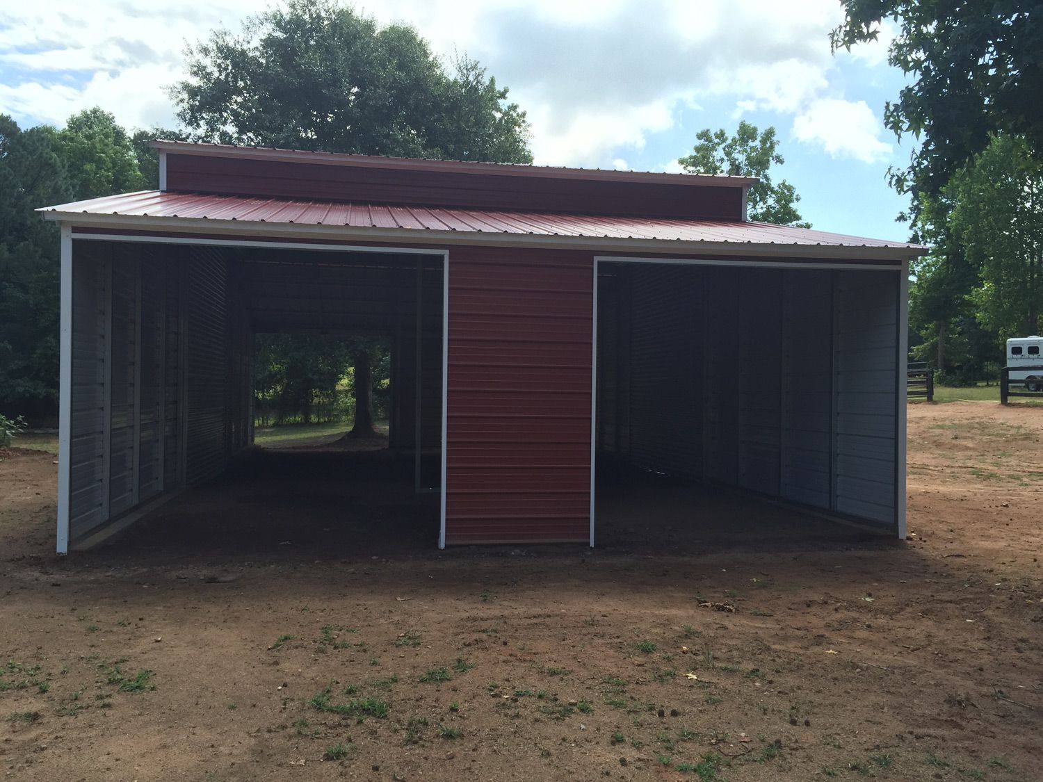 A red and white barn with the doors open