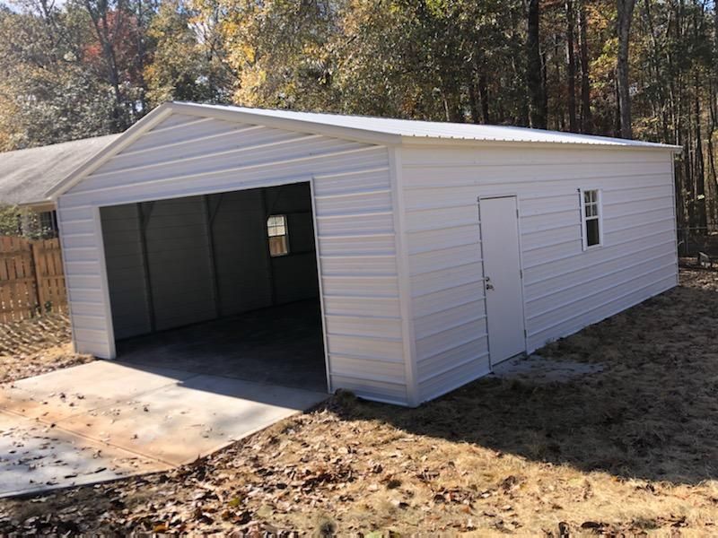A white garage with a concrete driveway and a window.