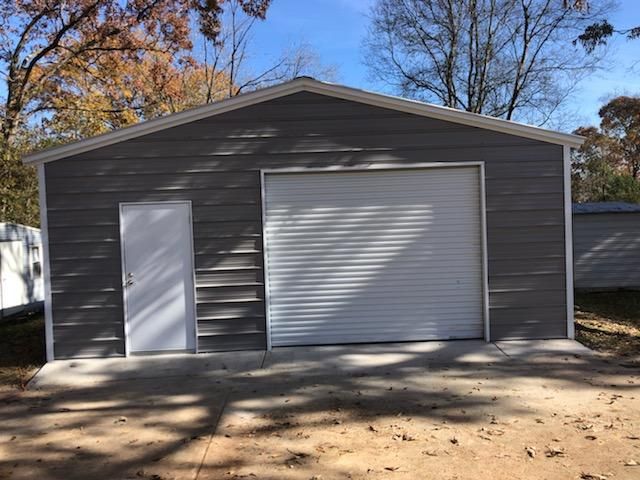 A garage with a white garage door and a white door.