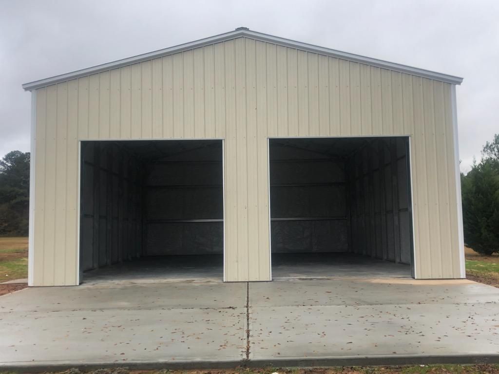 A white garage with two doors and a concrete driveway