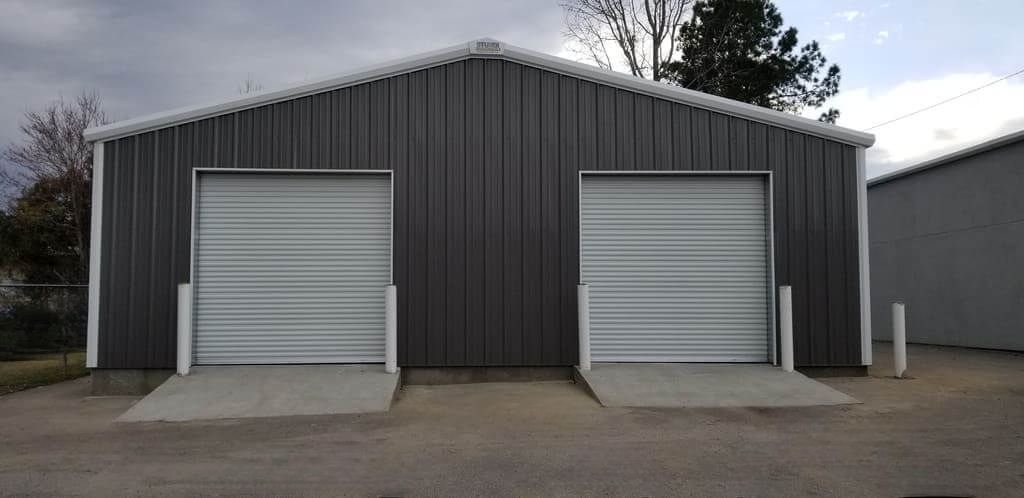 A garage with two garage doors and a ramp in front of it.