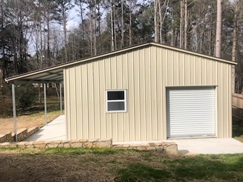 A metal garage with a carport and a window.