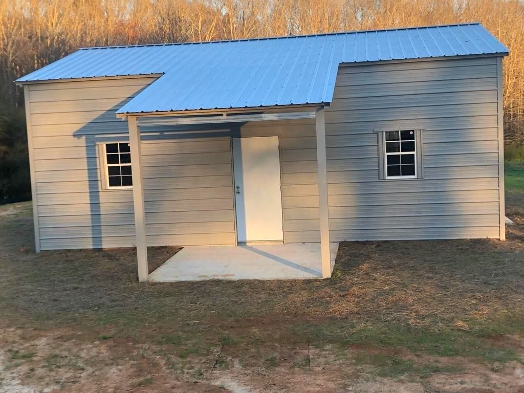 A small house with a metal roof and a porch