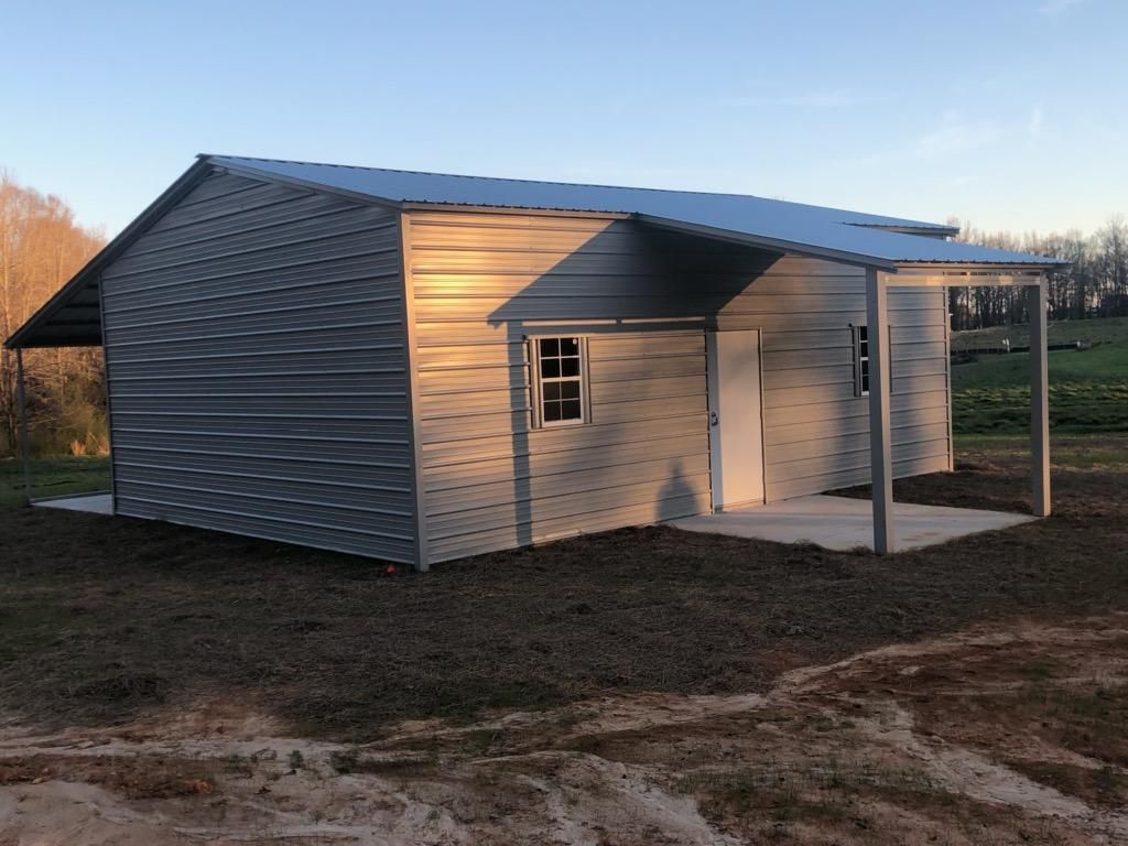 A small metal building with a porch and a window