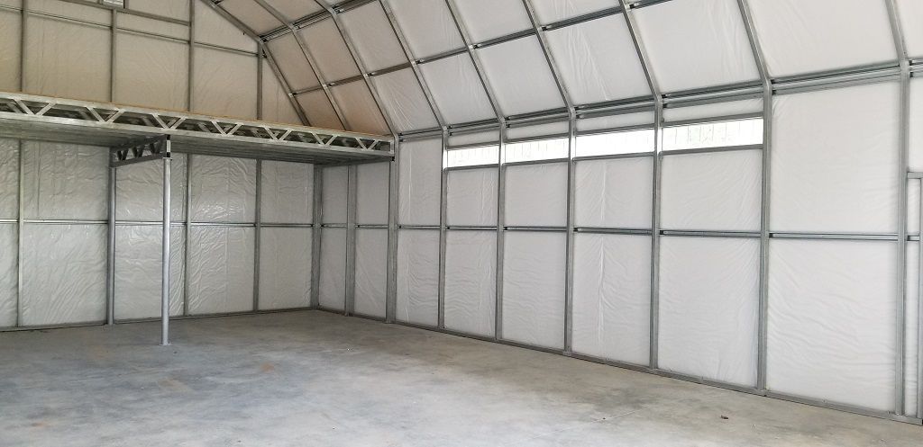 A large empty warehouse with white walls and a ceiling.
