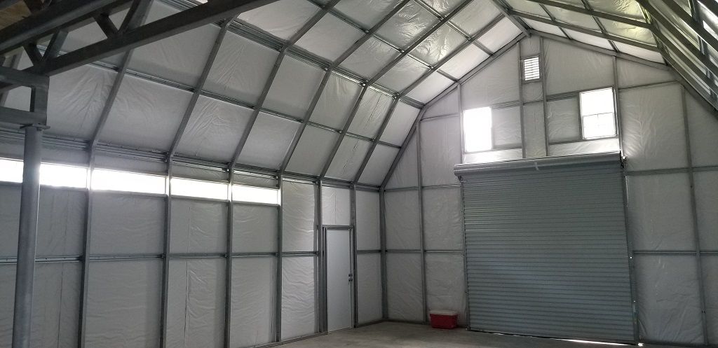 The inside of a large warehouse with a garage door.