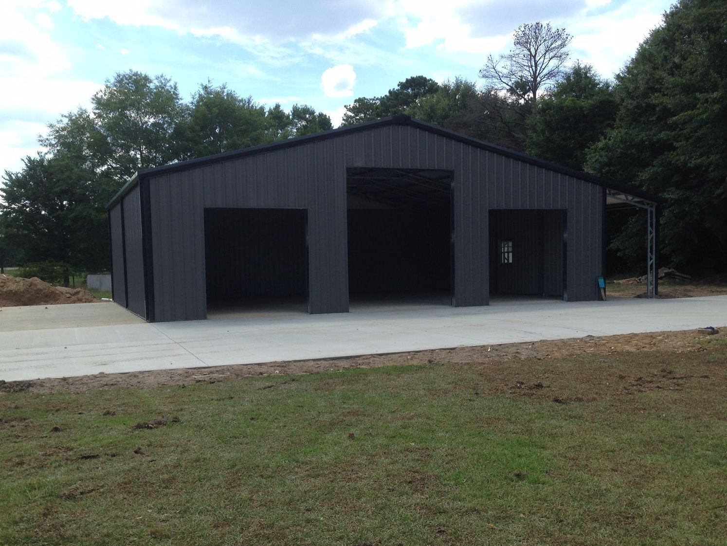 A large black building with a concrete driveway in front of it