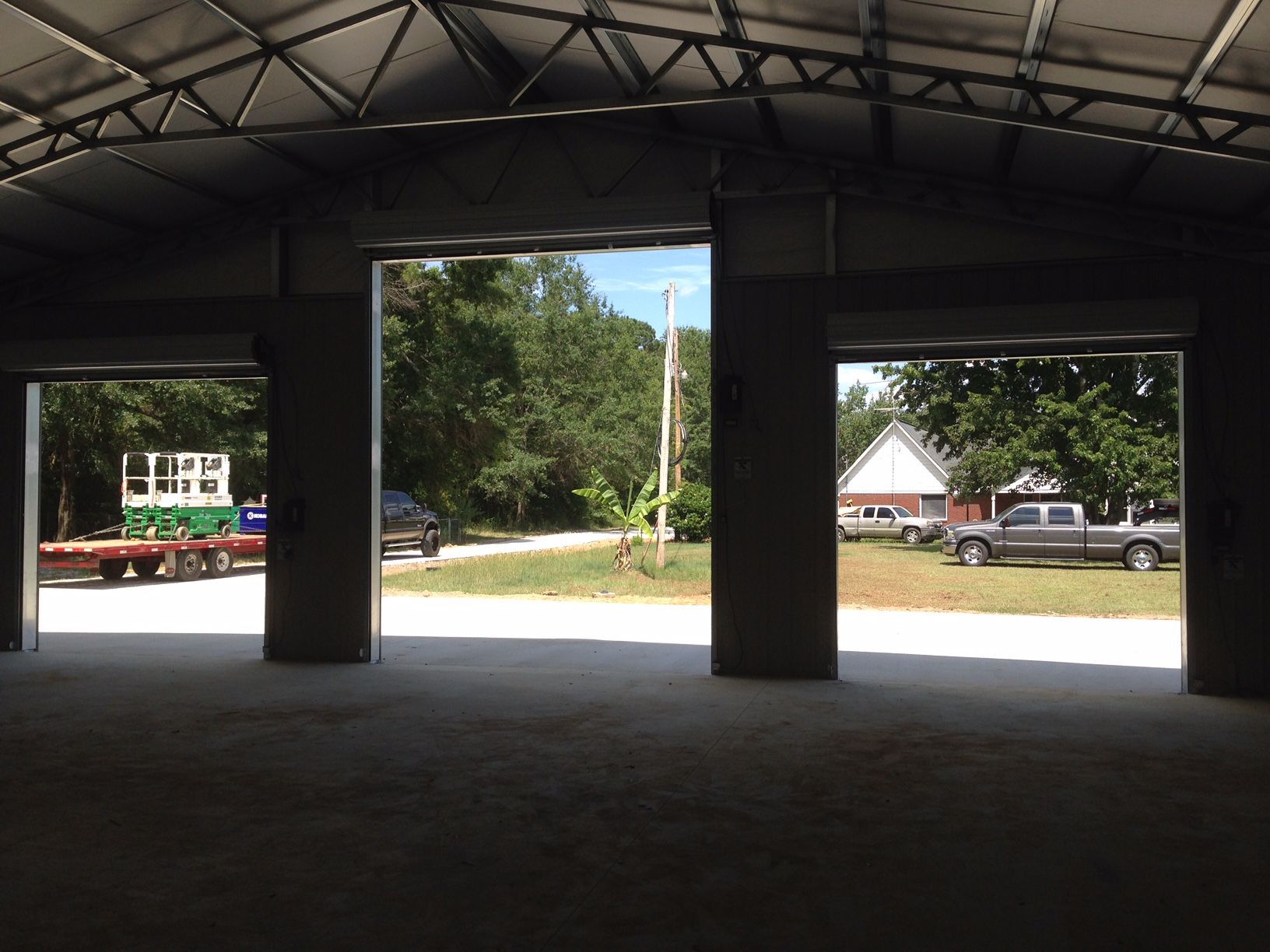 A truck is parked in a garage with the doors open