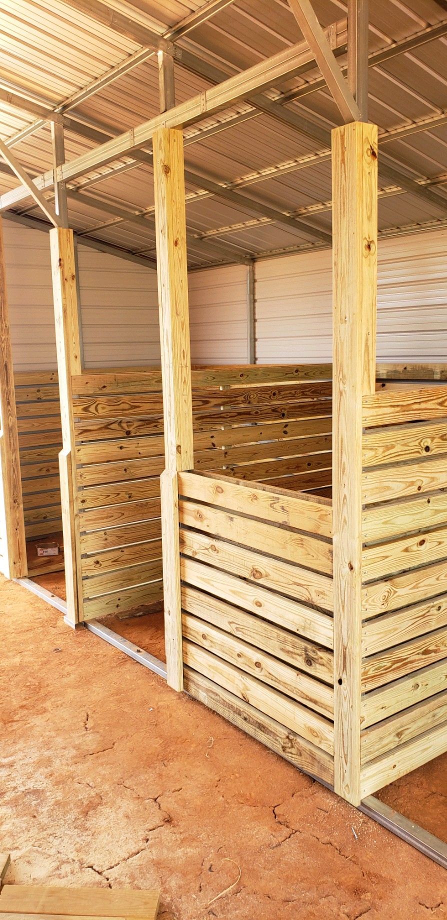 A wooden fence is being built in a barn.
