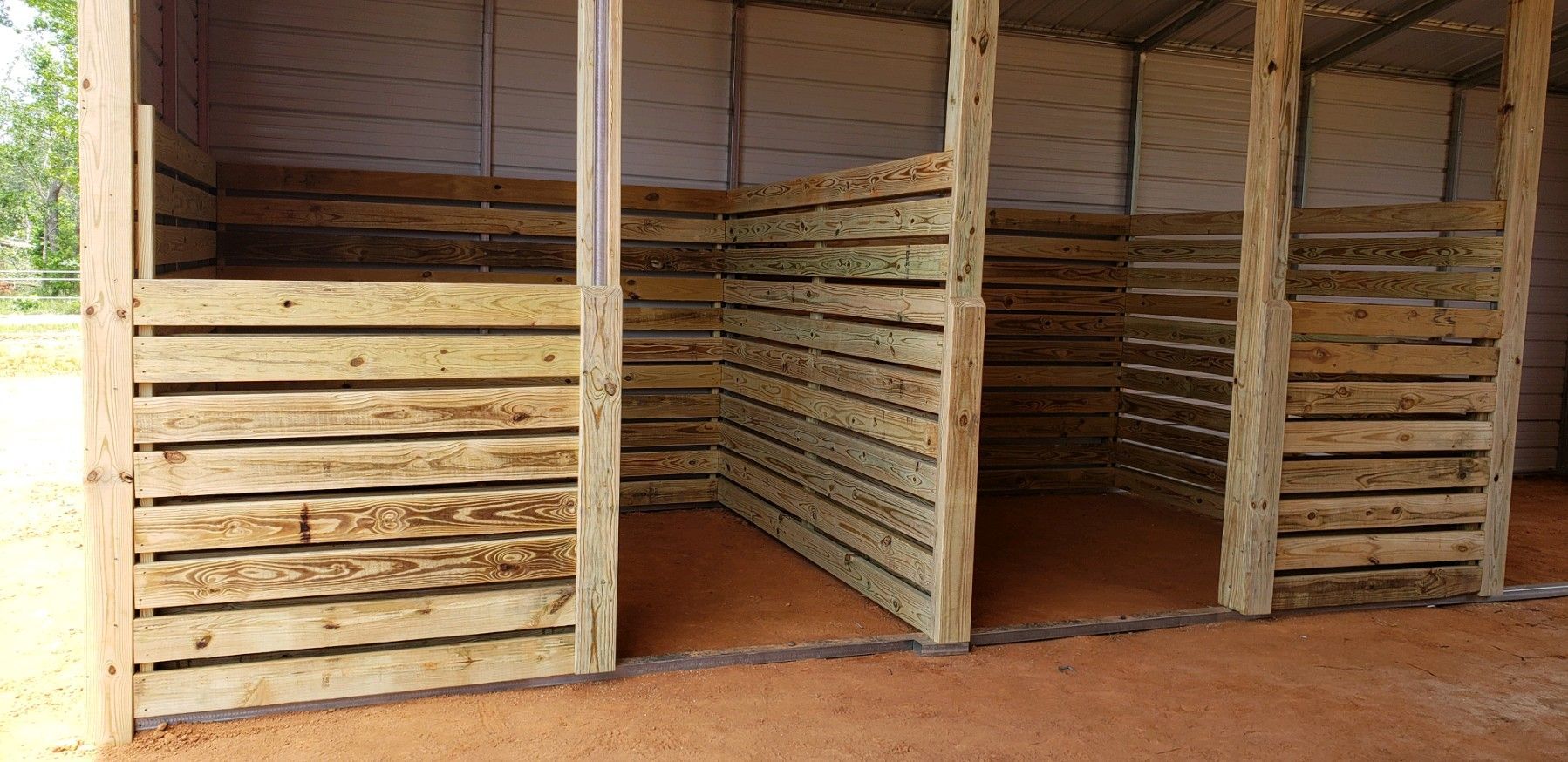 A wooden stable with a roof and walls made of wooden pallets.