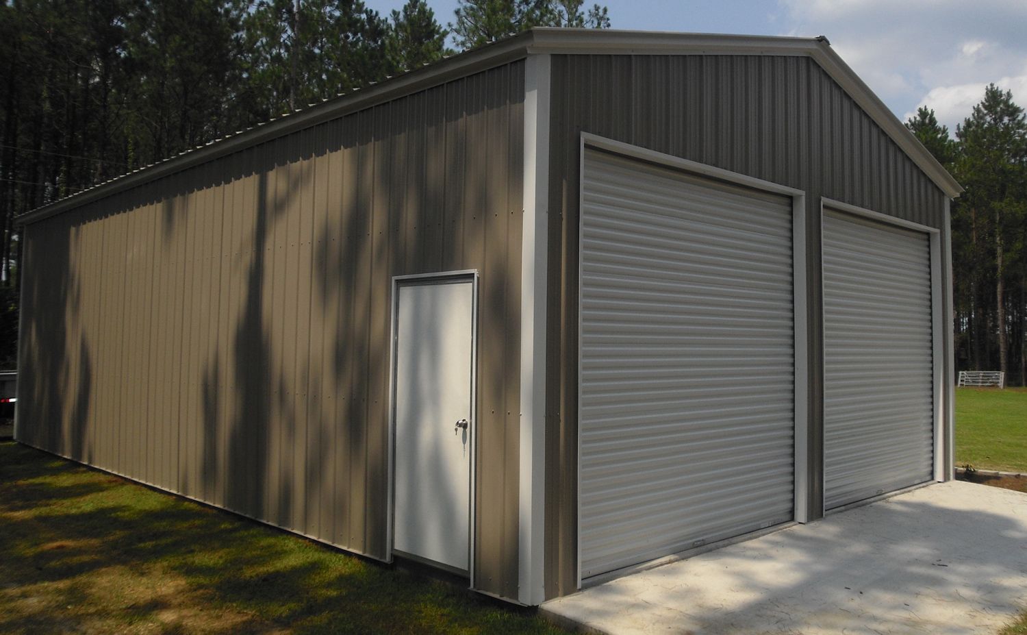 A large metal garage with two garage doors and a door.