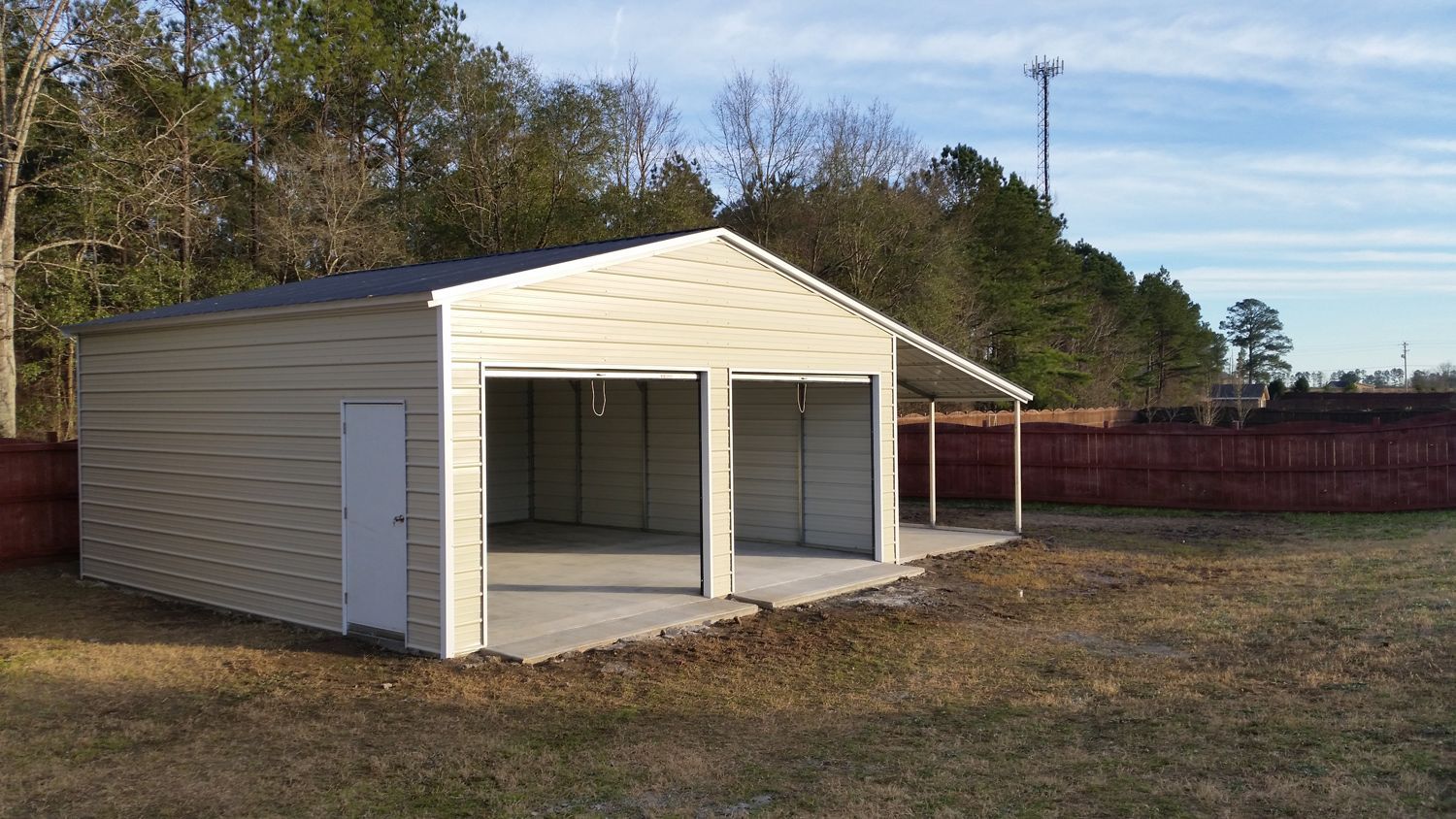 A white garage with a porch and a fence in the background.