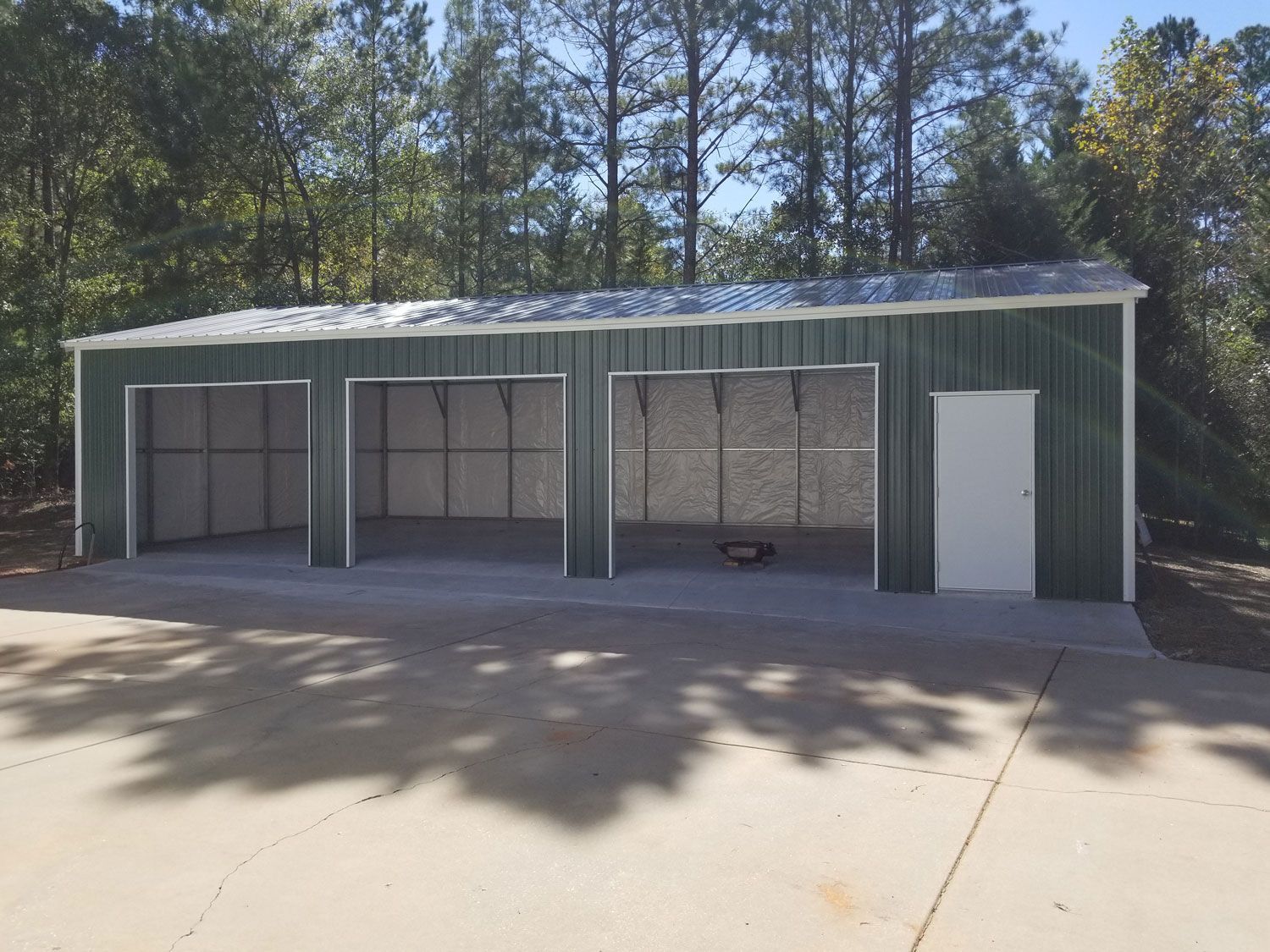 A large green metal garage with a white door