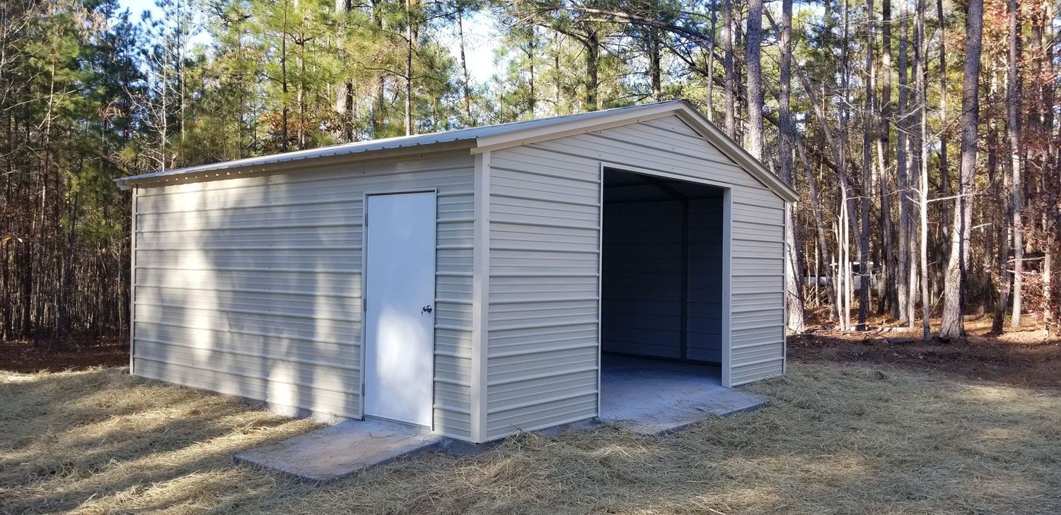 A metal shed with a white door is sitting in the middle of a grassy field.