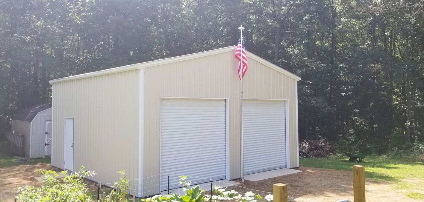 A garage with two garage doors and an american flag on top of it.