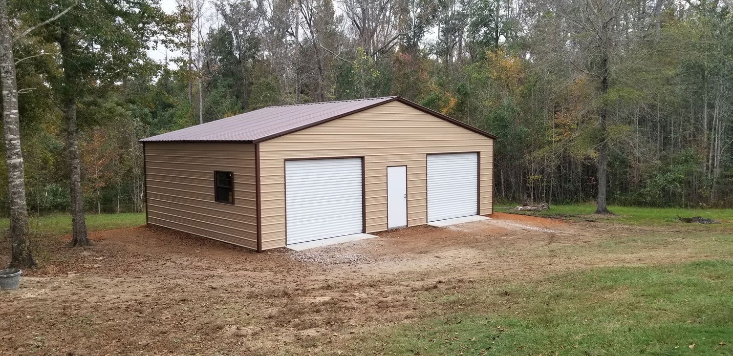 A metal garage with two garage doors is sitting in the middle of a grassy field.