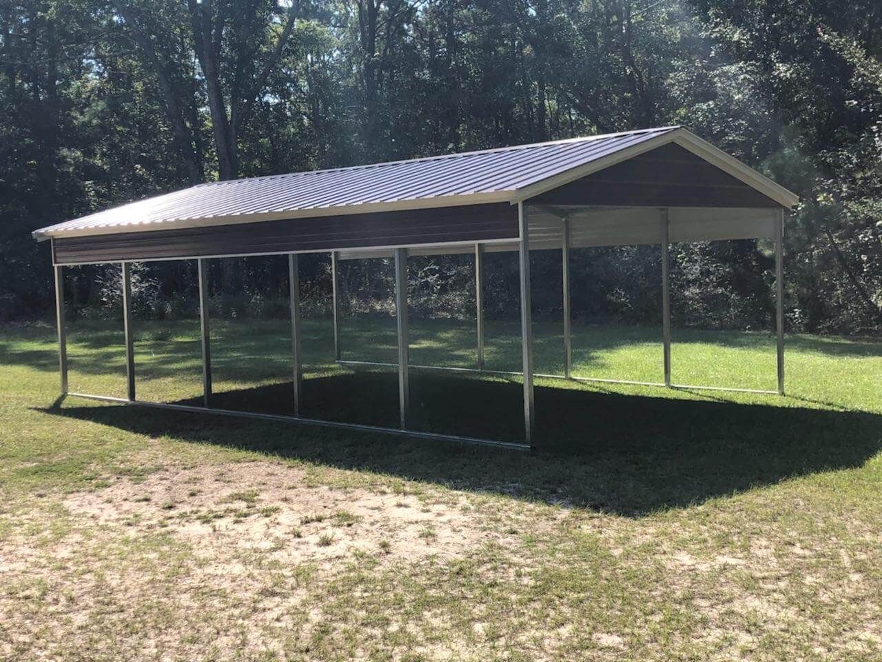A carport is sitting in the middle of a grassy field.