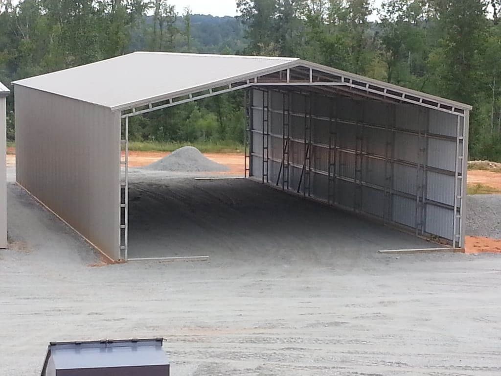 A large metal structure is sitting in the middle of a dirt field.