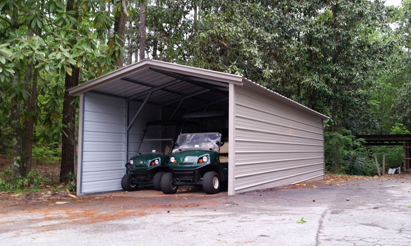 Two golf carts are parked in a metal garage.