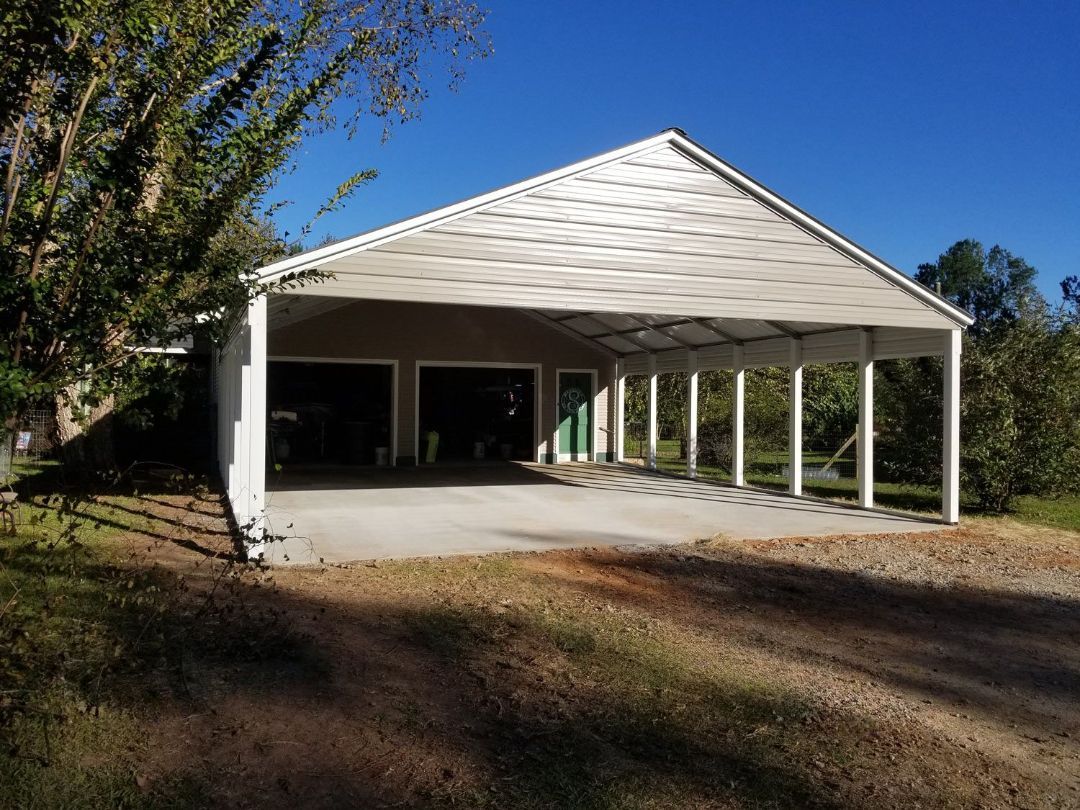 A large white garage with a driveway underneath it