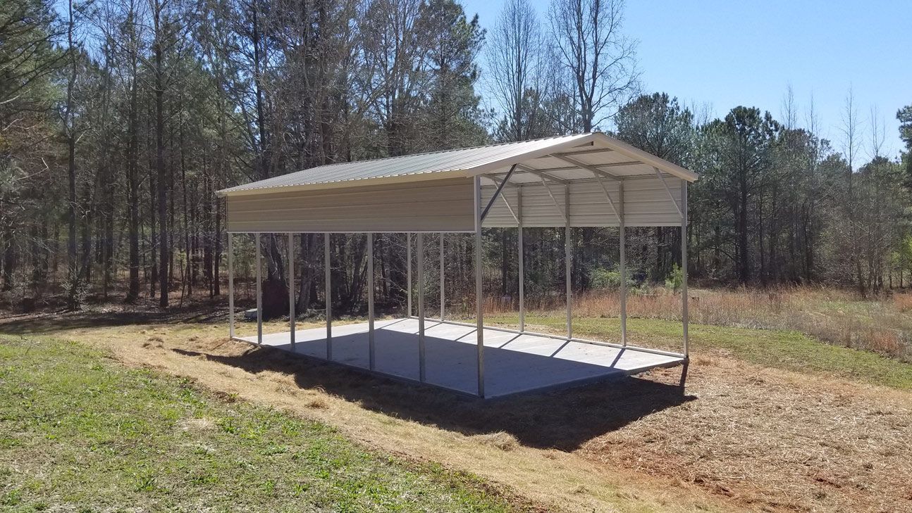 A carport is sitting in the middle of a grassy field.