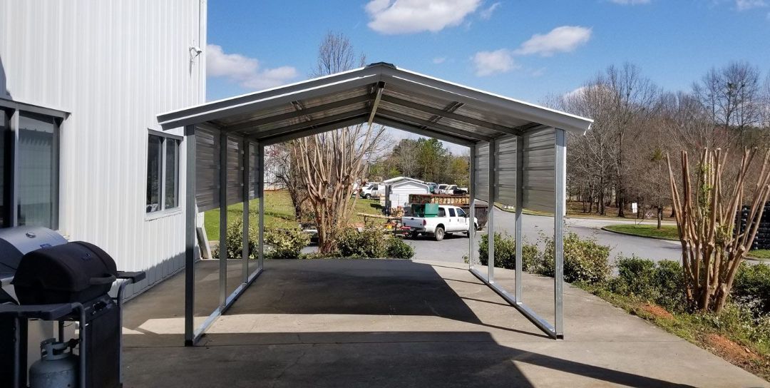 A carport is sitting on the side of a road next to a house.