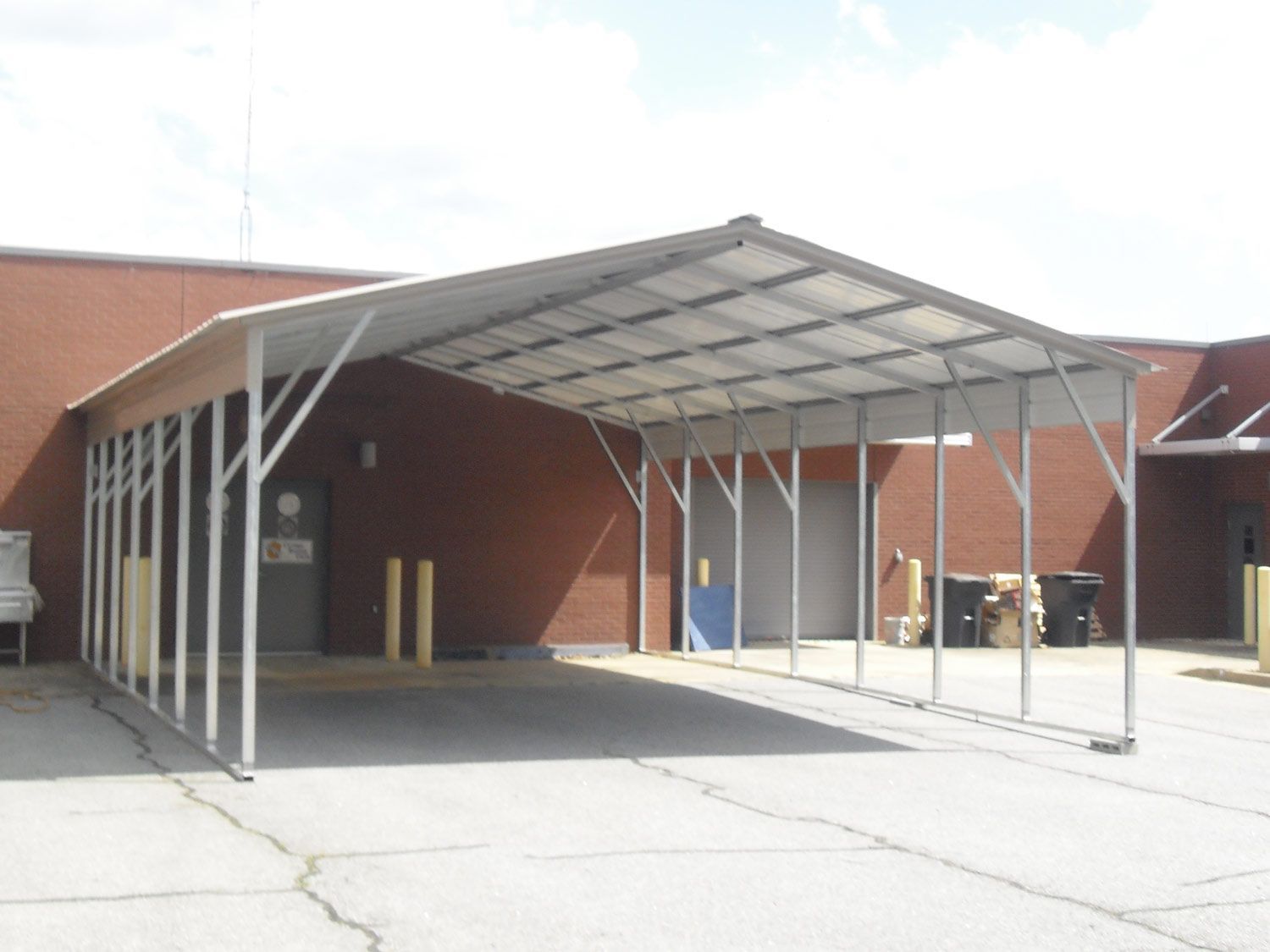 A carport in front of a red brick building