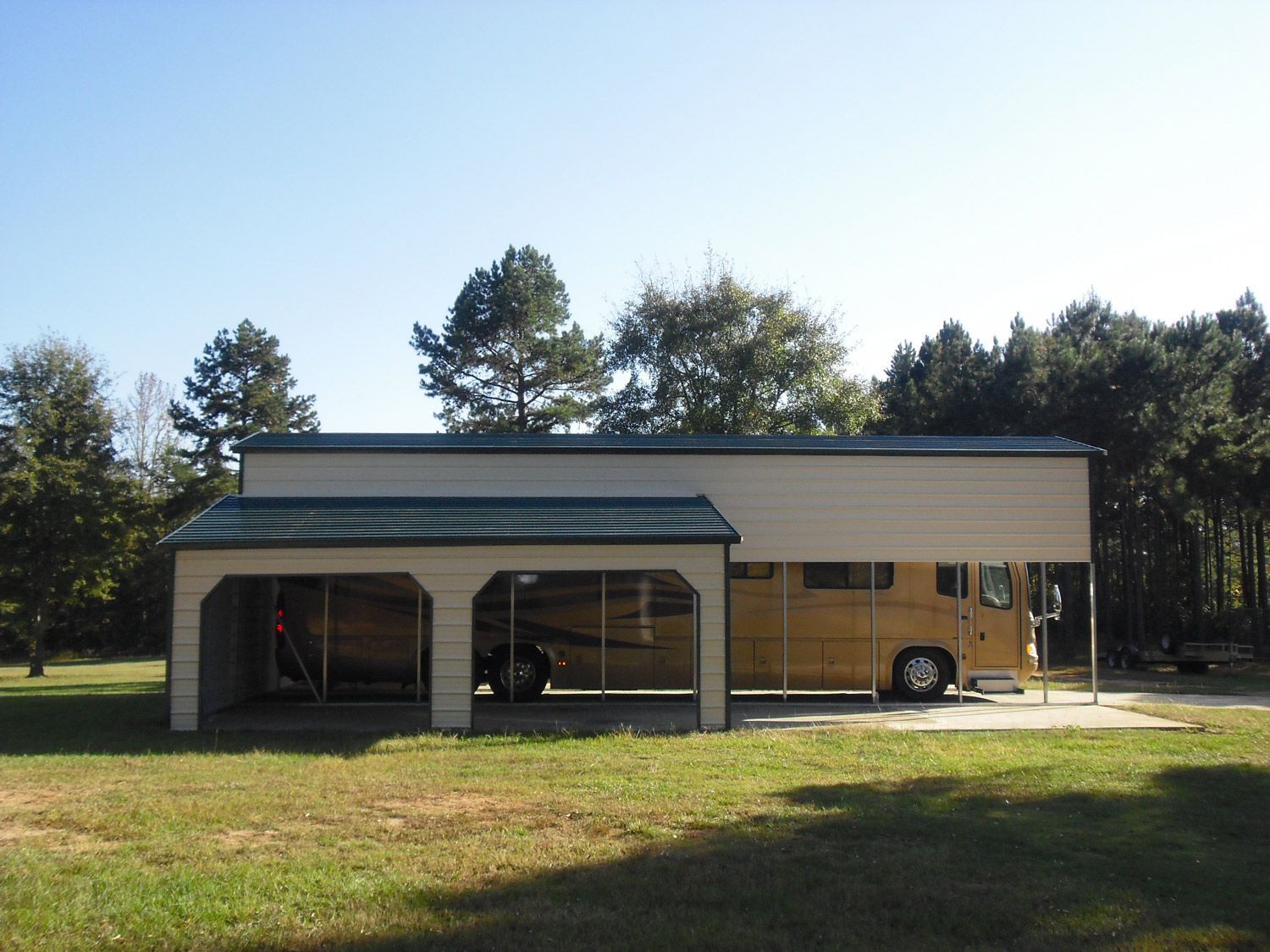 A horse trailer is parked under a carport