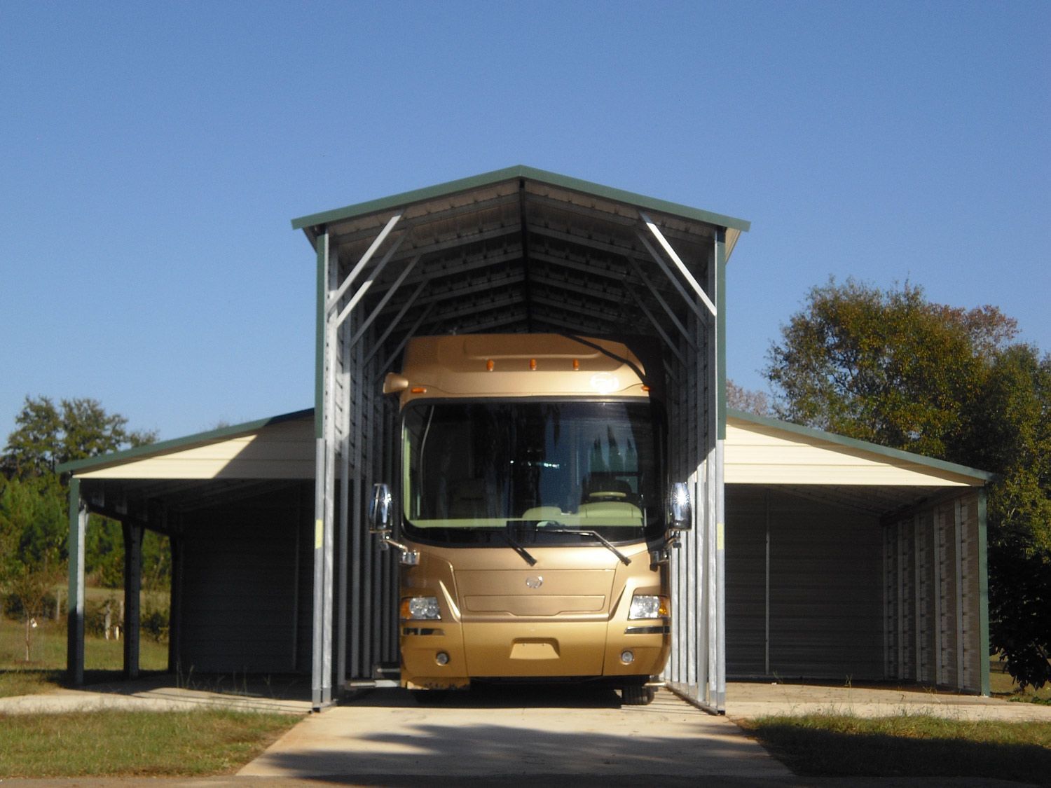A gold rv is parked under a carport