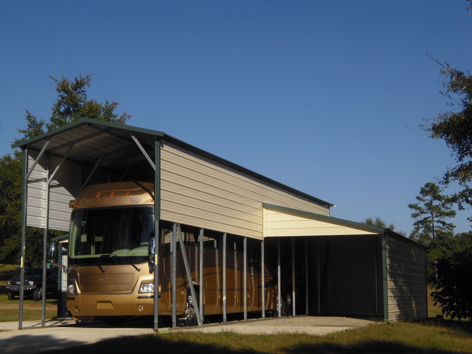 A rv is parked under a carport on a sunny day