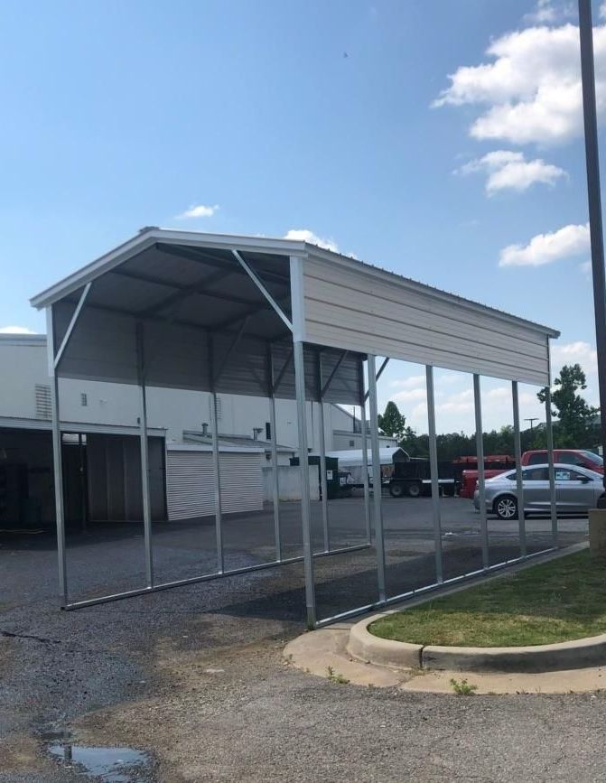 A carport is sitting in a parking lot next to a building.